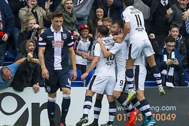 Dundee players celebrate Rory Loys second goal as Ross County defender Christopher Routis looks dejected.
Photograph: Gary Hutchison/SNS