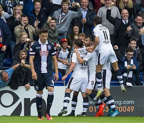 Dundee players celebrate Rory Loys second goal as Ross County defender Christopher Routis looks dejected.
Photograph: Gary Hutchison/SNS