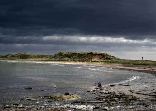 A boy skims stones on the beach at  Dunnet Bay as storm clouds gather.
Picture: Andrew Milligan/PA Wire