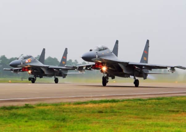 Two Chinese Su-30 fighter jets take off from an unspecified location to fly a patrol over the South China Sea. Picture: AP