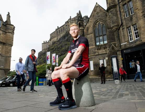 Rory Scholes, who has joined Edinburgh Rugby from Ulster, helps launch the capital clubs new kit in the Grassmarket yesterday. Picture: SNS