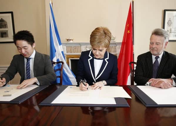 SinoFortone MD Zhang Yu and Sir Richard Heygate flank the First Minister as she signs the memo at Bute House in March