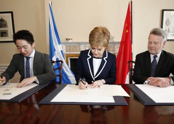 SinoFortone MD Zhang Yu and Sir Richard Heygate flank the First Minister as she signs the  memo at Bute House in March