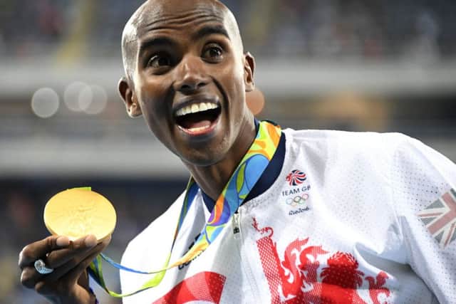 Mo Farah is all smiles with his gold medal after winning the 10,000m on Saturday. Picture: AFP/Getty Images