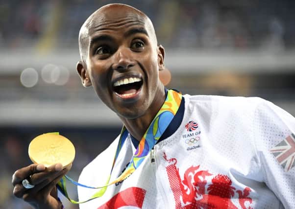 Mo Farah is all smiles with his gold medal after winning the 10,000m on Saturday. Picture: AFP/Getty Images