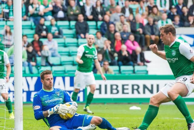 Dunfermline goalkeeper David Hutton holds on to the ball firmly as it comes back off the post with Hibs Grant Holt ready to pounce. Picture: Ian Georgeson