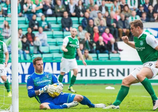 Dunfermline goalkeeper David Hutton holds on to the ball firmly as it comes back off the post with Hibs Grant Holt ready to pounce. Picture: Ian Georgeson