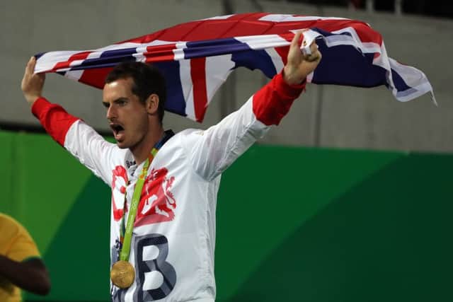 Andy Murray is draped in the flag after receiving the gold medal yesterday. Picture: PA