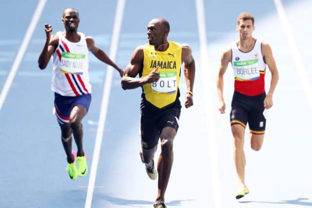 Usain Bolt has a casual look at his rivals as he coasts to victory in the heats of the men's 200m.  Picture: Paul Gilham/Getty Images