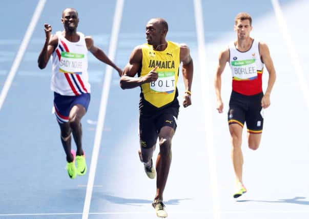 Usain Bolt has a casual look at his rivals as he coasts to victory in the heats of the men's 200m.  Picture: Paul Gilham/Getty Images