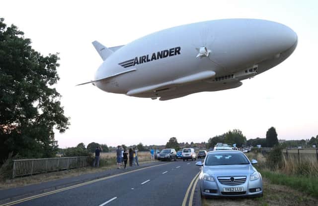 The Airlander 10 is seen in the air over a road on its maiden flight. Picture: Getty Images