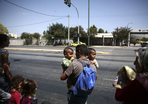 Migrants leave the Greek asylum service in Athens. Picture: AP