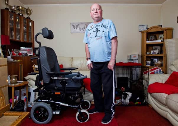 Ian Kennedy, 63, stands beside the motorised wheelchair he has been using since his accident. Picture: John Jeffay