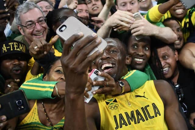 Usain Bolt takes a selfie as he celebrates with fans after winning the Olympic 200m final in Rio. Picture: Damien Meyer/AFP/Getty Images