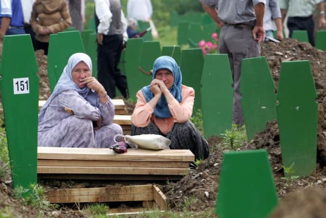 Bosnian Muslim women sit at Potocari cemetery, outside Srebrenica. Picture: AP