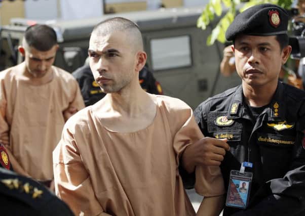 Suspects in the bombing which killed 20 people in August last year, Bilal Mohammad and Mieraili Yusufu arrive at a military court in Bangkok. Picture: AP