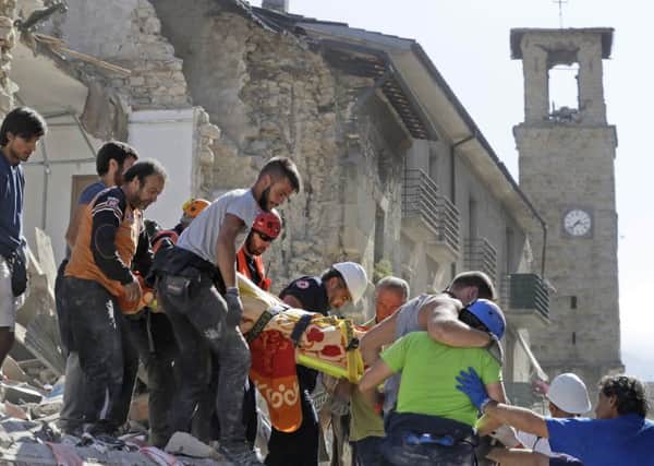 Rescuers stretcher a casualty from a building following the earthquake. AP Photo/Alessandra Tarantino