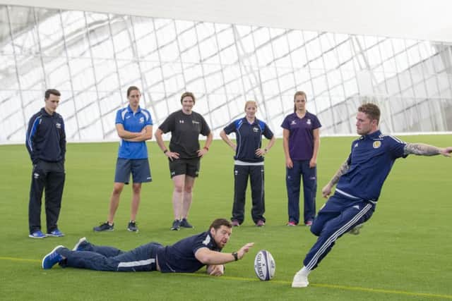 Scotland squad keeper Jack Hamilton kicks a rugby ball in the new Oriam indoor pitch assisted by Scotland prop Alasdair Dickinson. Picture Ian Rutherford