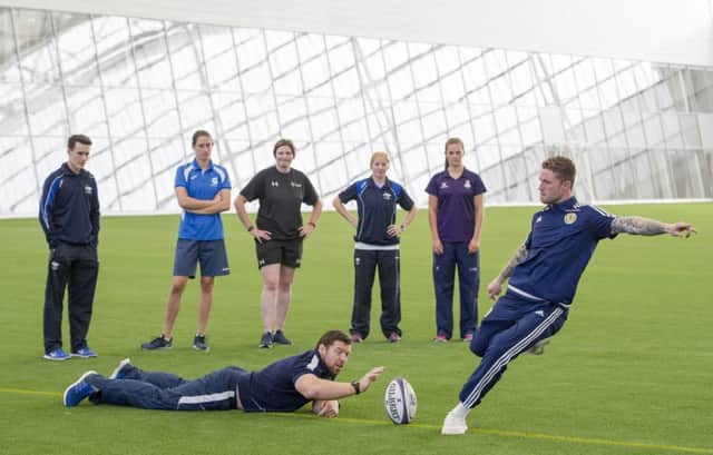 Scotland squad keeper Jack Hamilton kicks a rugby ball in the new Oriam indoor pitch assisted by Scotland prop Alasdair Dickinson. 
Picture Ian Rutherford