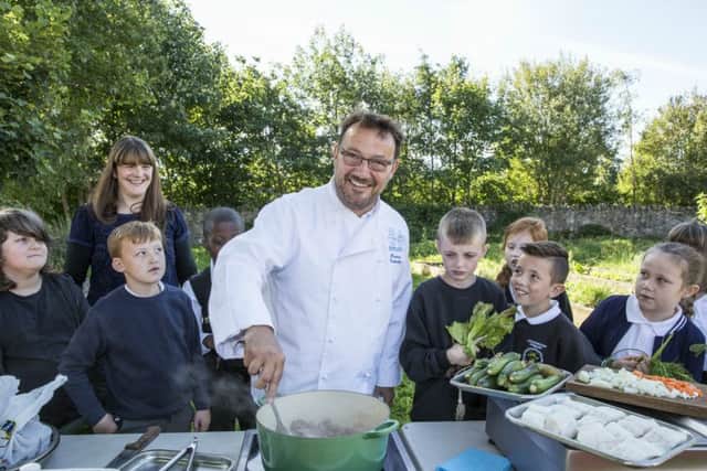 Fred Berkmiller demonstrates healthy cooking for Eleanor Cunningham and pupils from Gracemount Primary School. Picture: Contributed