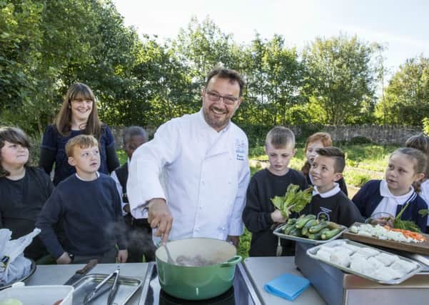 Fred Berkmiller demonstrates healthy cooking for Eleanor Cunningham and pupils from Gracemount Primary School. Picture: Contributed