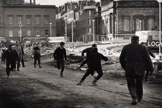 Tay Road Bridge workers play football on their break in one of the photographs by Joseph McKenzie