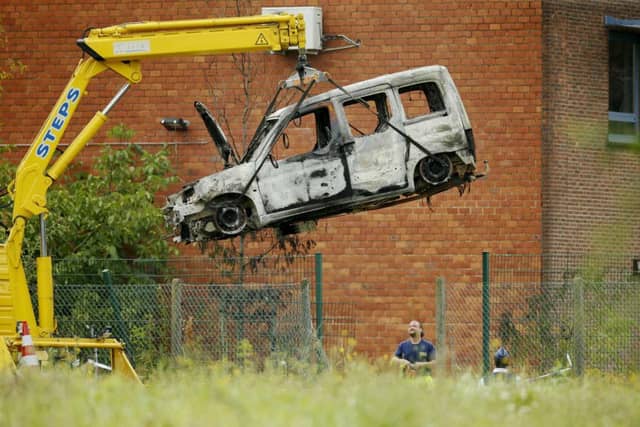 The burnt-out car used to ram the National Institute for Criminalistics and Criminology is removed from the scene in Brussels. Picture: AFP/Getty Images