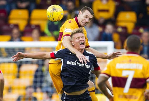 Motherwell defender Stephen McManus rises above Dundee's Mark O'Hara