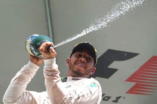 Lewis Hamilton celebrates becoming the first driver to claim a spot on the podium at the Belgian Grand Prix after starting the race from as far back as 21st place on the grid. Picture: AFP/Getty