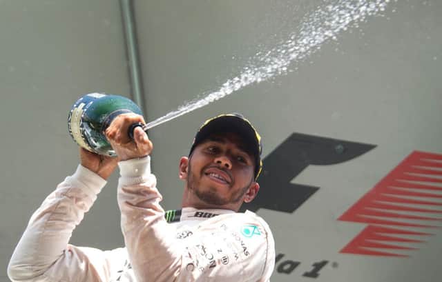 Lewis Hamilton celebrates becoming the first driver to claim a spot on the podium at the Belgian Grand Prix after starting the race from as far back as 21st place on the grid. Picture: AFP/Getty
