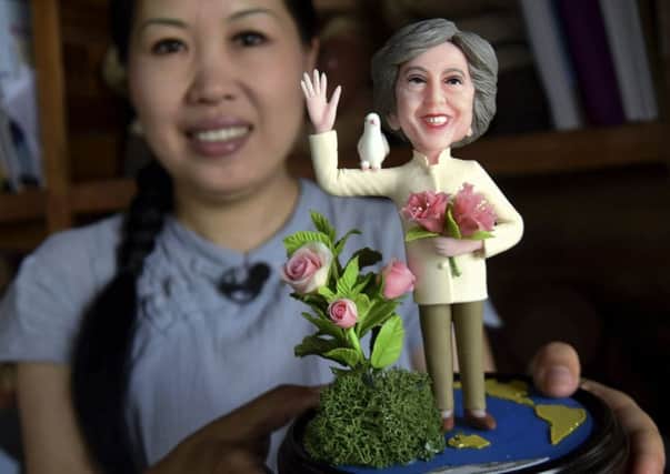 An artist shows a clay figure of Theresa May to mark the summit. Picture: AP