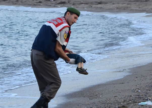 A Turkish police officer carries the body of three-year-old Aylan Kurdi off the beach in Bodrum, southern Turkey. Picture: Getty