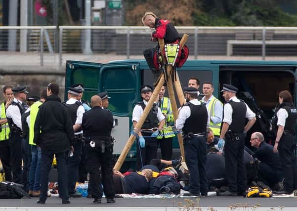 Emergency services surround protestors from the movement Black Lives Matter after they locked themselves to a tripod on the runway at London City Airport. Picture: Leal Olivas/AFP/Getty Images