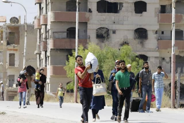 Syrian civilians from the town of Daraya are evacuated from the rebel-held town of Moadamiyet al-Sham. Picture: AFP/Getty Images