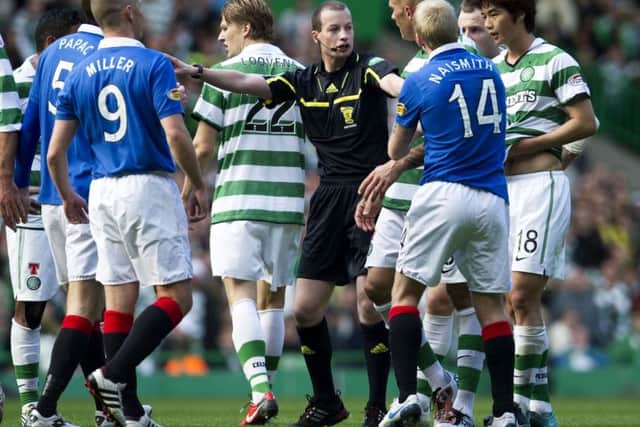 Referee Willie Collum is surrounded by players from both sides during the Old Firm derby at Celtic Park in October 2010. Picture: SNS Group.