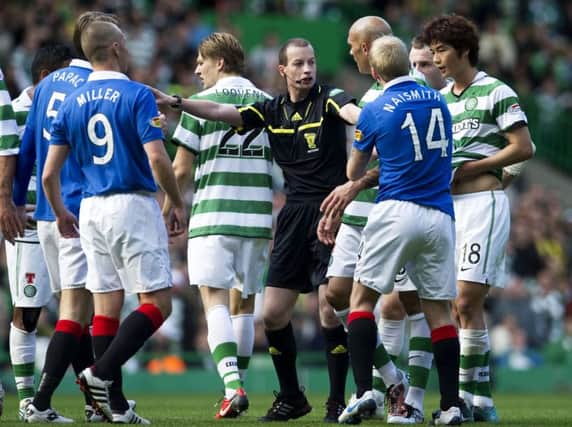 Referee Willie Collum is surrounded by players from both sides during the Old Firm derby at Celtic Park in October 2010. Picture: SNS Group.