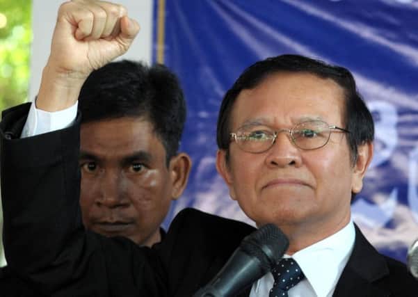 Cambodian opposition party deputy leader Kem Sokha (R) raises his fist during his speech at the Cambodia National Rescue Party (CNRP) headquarters in Phnom Penh. Picture: Getty