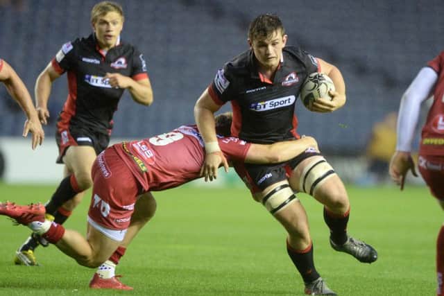 Edinburghs Magnus Bradbury evades the clutches of Scarlets Aled Davies. Pic: SNS/SRU