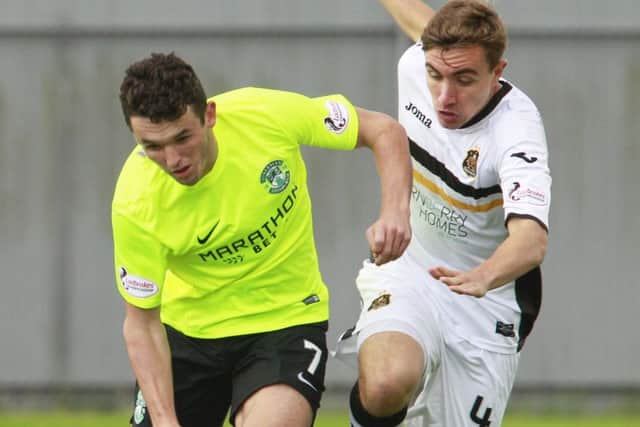 Hibs midfielder John McGinn tries to fend off the attention of Dumbartons Joe Thomson. Picture: SNS