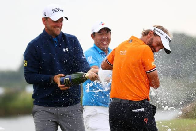 Bernd Wiesberger, left, and Byeong-hun An spray champagne on Joost Luiten of the Netherlands after his KLM Open victory. Picture: Getty
