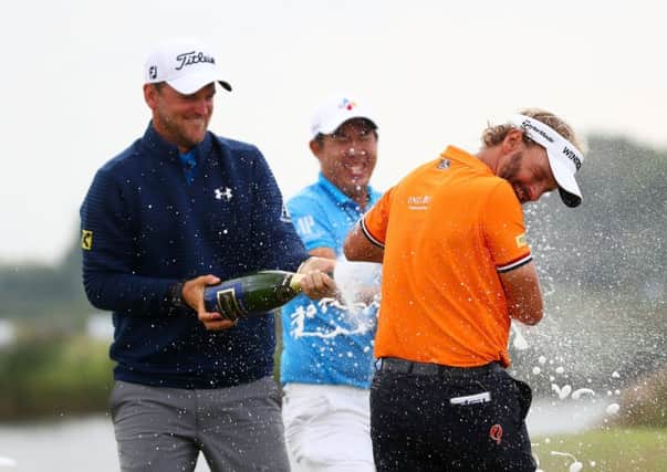 Bernd Wiesberger, left, and Byeong-hun An spray champagne on Joost Luiten of the Netherlands after his KLM Open victory. Picture: Getty