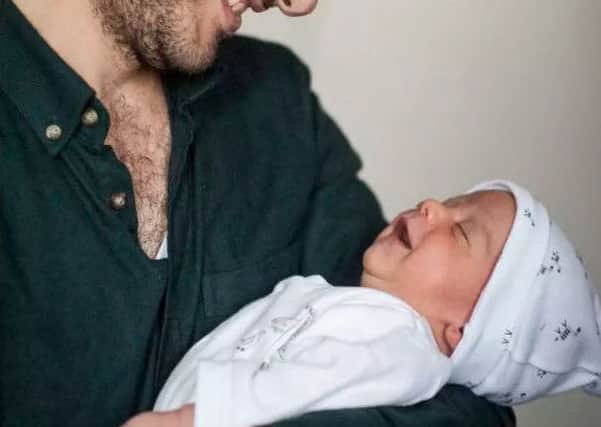 Abdulrazaq Alhallaq holding his baby, Omar, who was born three weeks ago in a Scottish hospital (Photo: Martin Hunter)