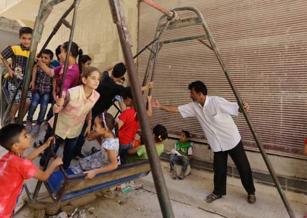 Syrian children play on a street in a residential suburb of the Syrian capital Damascus, on the second day of the Eid al-Adha Muslim holiday. Picture: Getty
