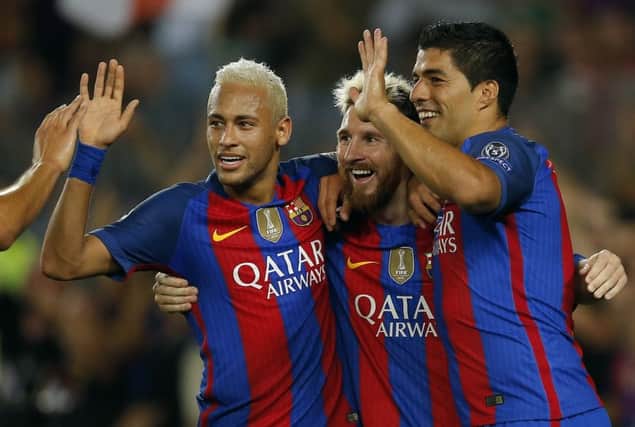 Barcelona's Lionel Messi, centre, celebrates his hat-trick goal with team-mates Neymar, left, and Luis Suarez. Picture: Manu Fernandez/AP