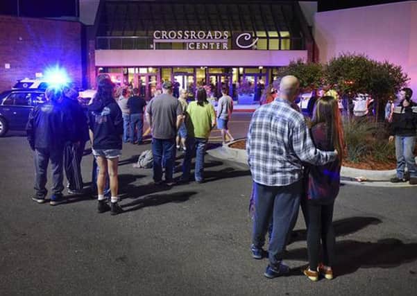People stand near the entrance on the north side of Crossroads Center mall as officials investigate the incident. Picture: AP
