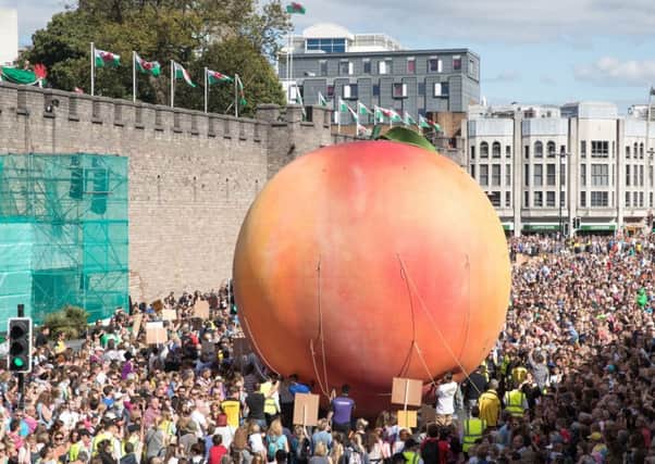 Members of the public gather in Cardiff to watch a giant peach being moved through the streetds to mark Roald Dahl's centenary. Picture: Getty Images