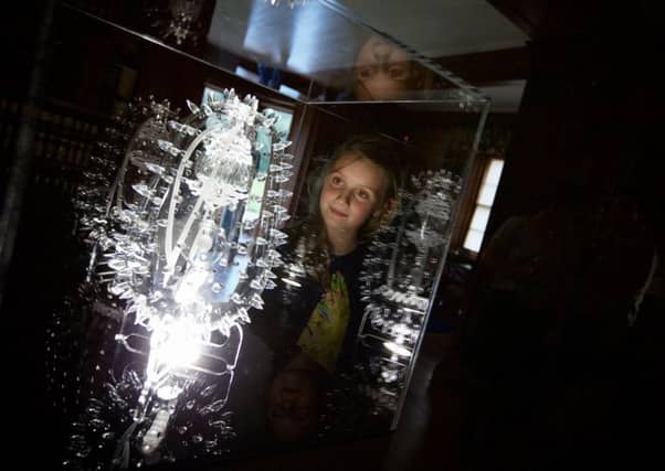 Nine year-old Corrie Eccles Boyd from Ferness stares into a piece, 'Malaria' by artist Luke Jerram. Part of a collection of his Glass Microbiology work on show at Brodie Castle as part of the Findhorn Bay Arts Festival. Photograph: Paul Campbell.