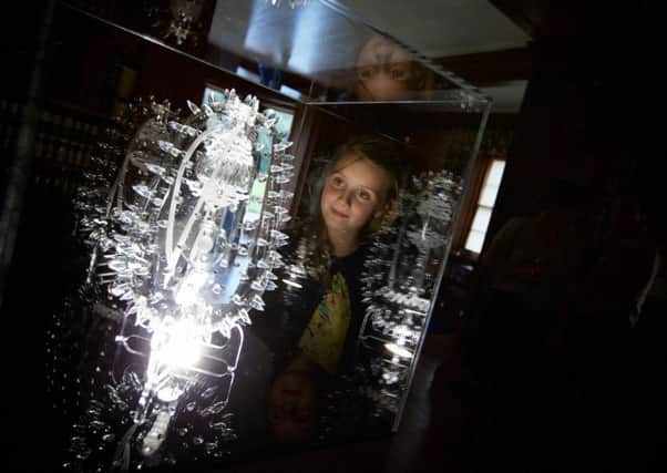 Nine year-old Corrie Eccles Boyd from Ferness stares into a piece, 'Malaria' by artist Luke Jerram. Part of a collection of his Glass Microbiology work on show at Brodie Castle as part of the Findhorn Bay Arts Festival.  Photograph: Paul Campbell.