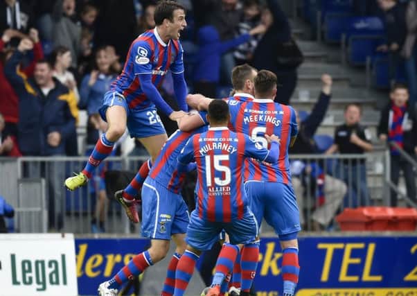 Inverness players celebrate after Alex Fisher (hidden) scores a late equaliser. Picture: SNS.