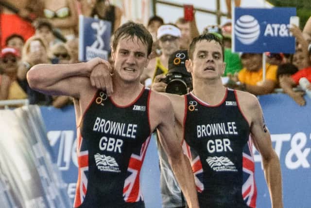 Alistair Brownlee (L) helps his brother Jonny before crossing the line. Picture: AFP/Getty